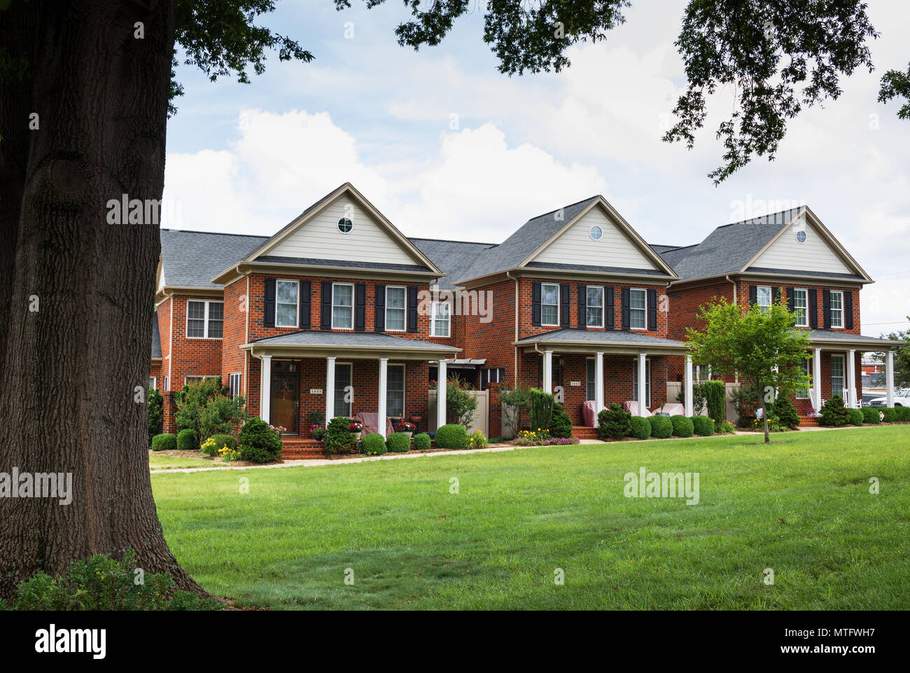 HICKORY, NC, USA-27 18. MAI: Eine Reihe von 3 eleganten Stadthäusern aus Backstein mit einer Fläche von grünen Rasen vor. Stockfoto