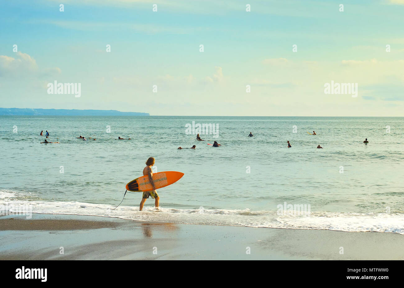 Surfer gehen zu Surfen in den Ozean. Die Insel Bali ist einer der Weltbesten surfen Reiseziele Stockfoto