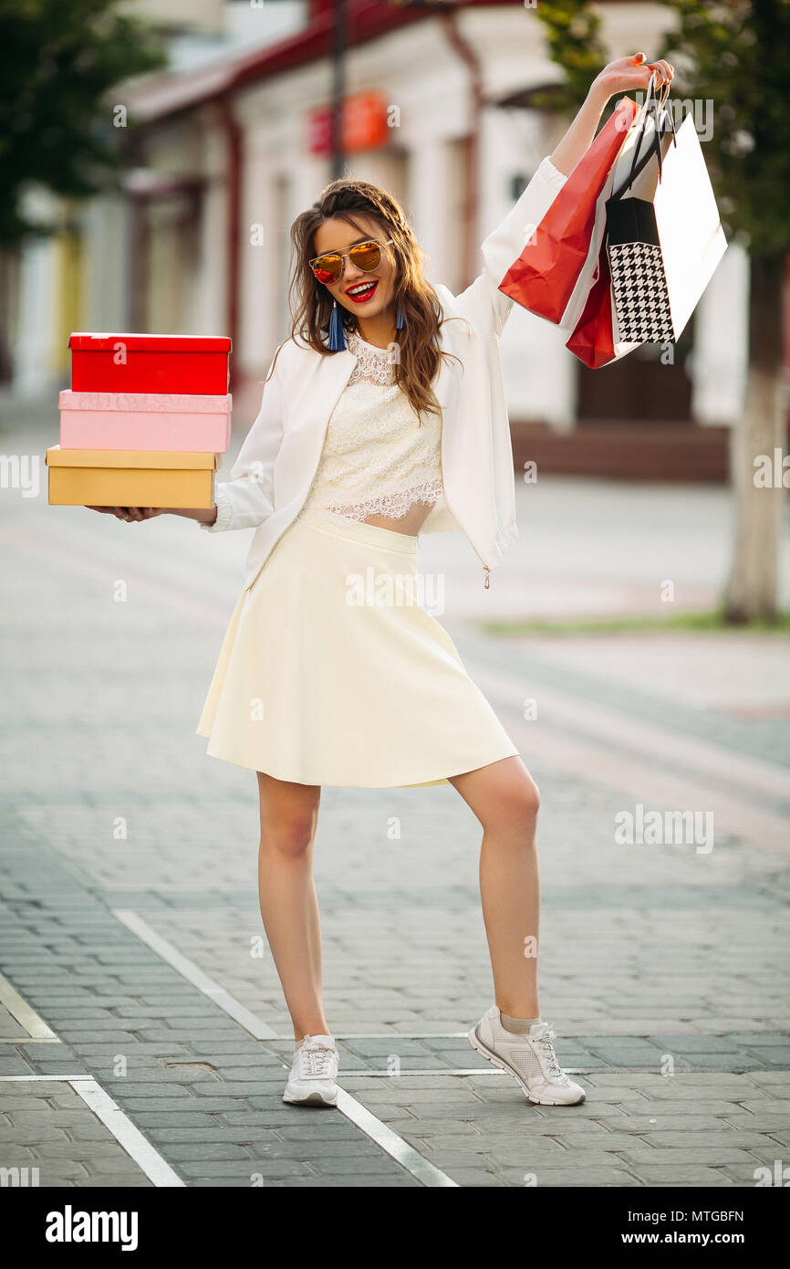Gerne Modell in Weiß sieht und Sonnenbrille holding Einkaufstaschen u Stockfoto