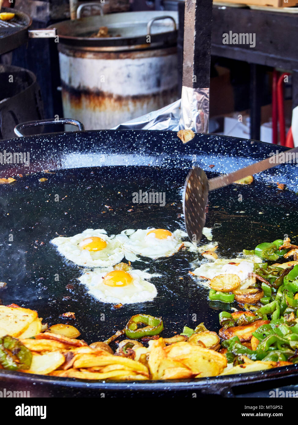 Spanische Eier im Gange. Gebratene Eier mit Kartoffeln und Paprika in der Pfanne. Spanisch Street Food. Stockfoto
