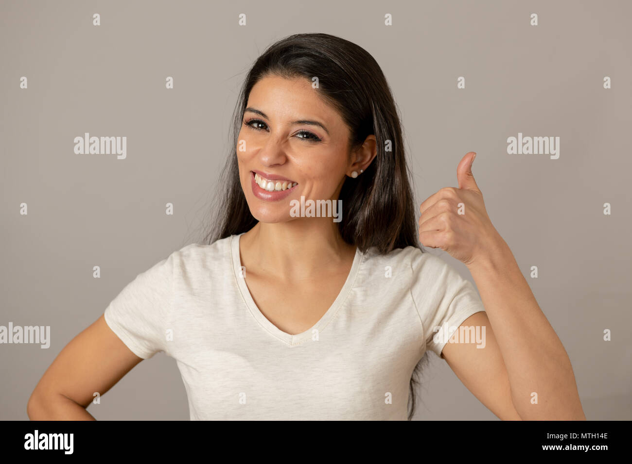 In der Nähe von schönen jungen latin Hispanic Frau mit einem glücklichen Gesicht. Schönes Lächeln und "Daumen hoch" Geste. Positive menschliche Mimik Stockfoto