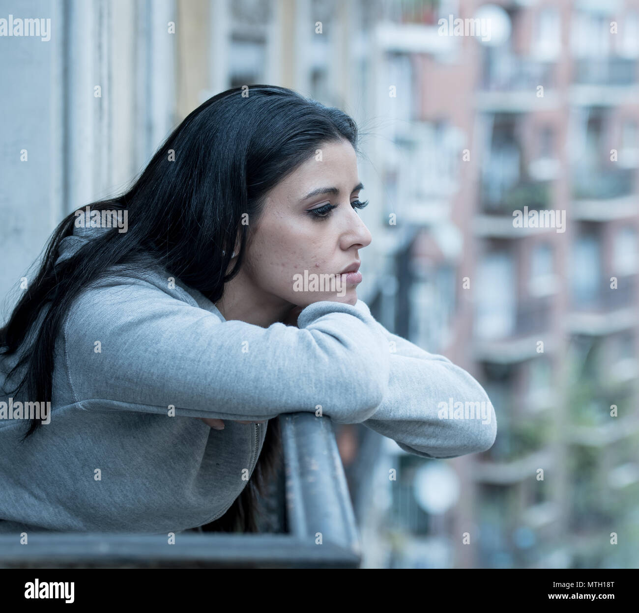 Schönen lateinischen gedrückt einsame Frau starrte traurig, Schmerz und auf einem Balkon zu Hause besorgt. Krise, Depression und psychische Gesundheit Konzept Stockfoto