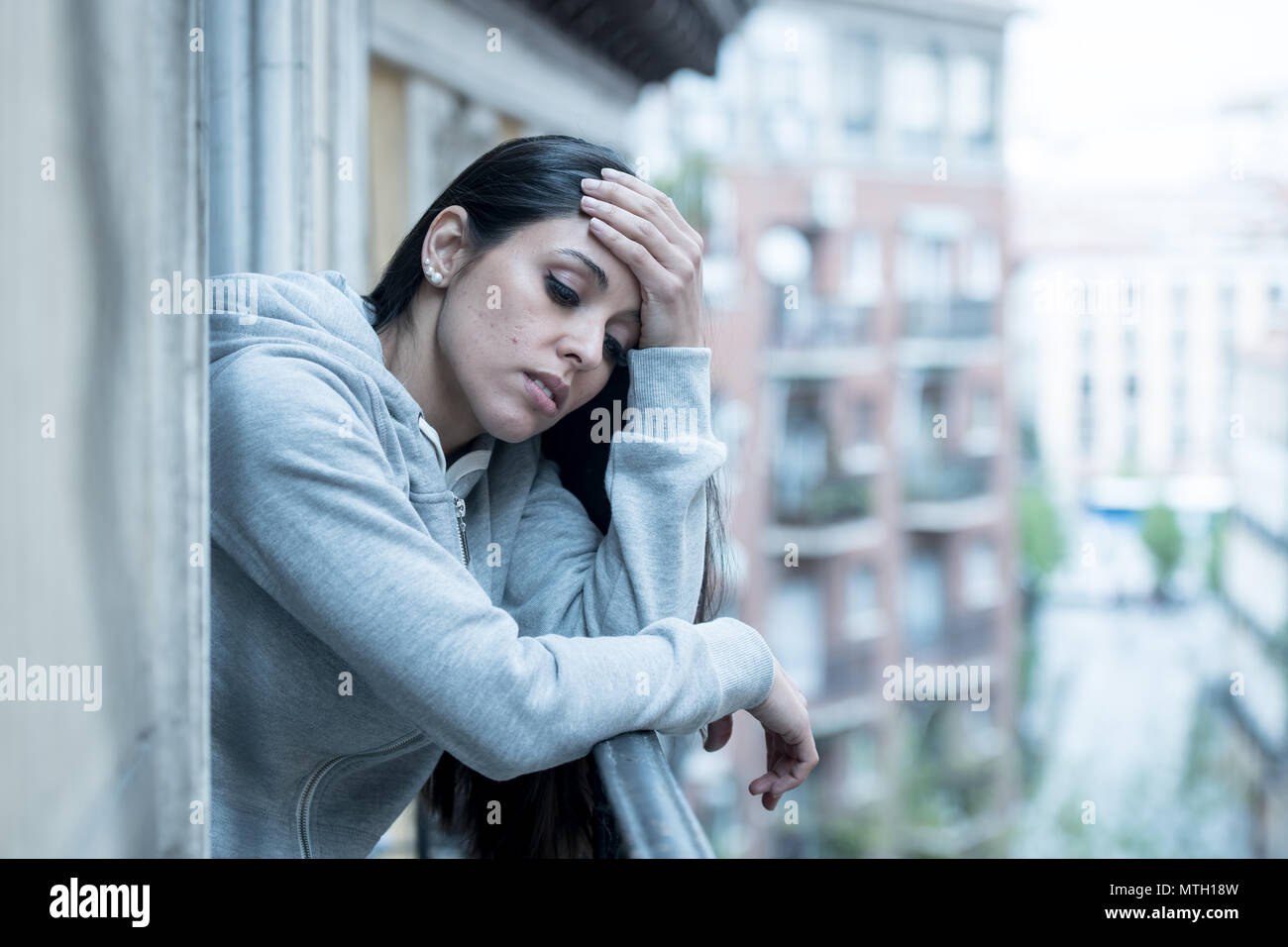 Schönen lateinischen gedrückt einsame Frau starrte traurig, Schmerz, Trauer, auf dem Balkon zu Hause. Krise, Depression und psychische Gesundheit Konzept Stockfoto