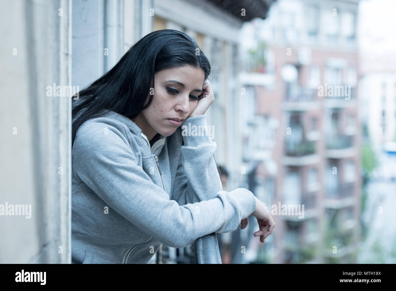 Attraktive latin gedrückt einsame Frau starrte traurig, Schmerz, Trauer, auf dem Balkon zu Hause. Krise, Depression und psychische Gesundheit Konzept Stockfoto