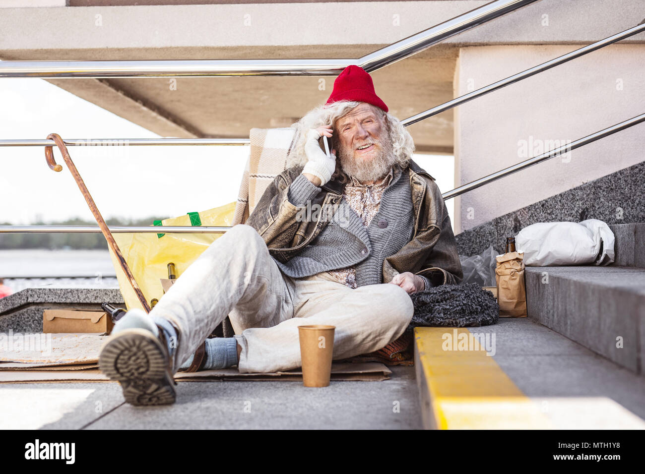 Fröhlich Straße Bettler einen Anruf tätigen Stockfoto