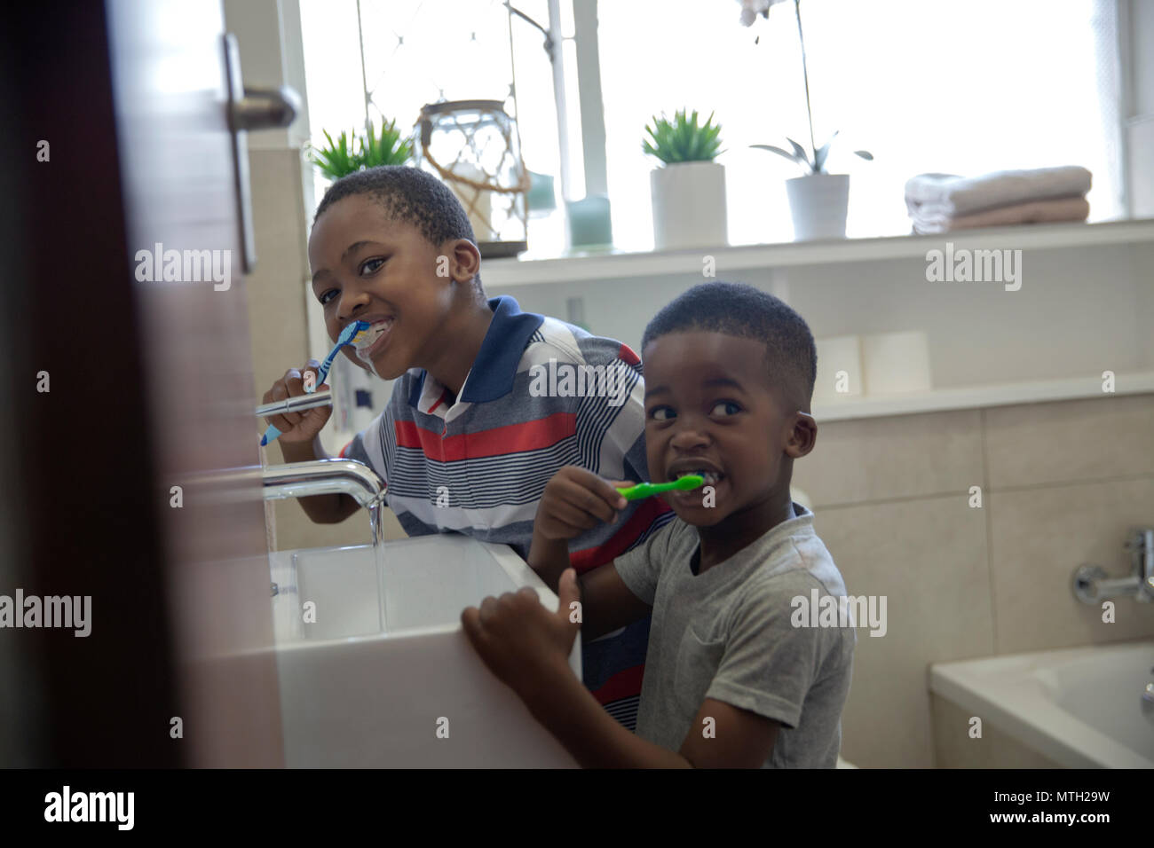 Jungen Zähneputzen im Badezimmer Stockfoto
