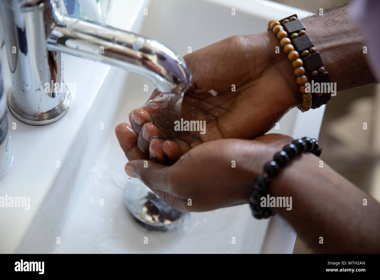 Mann Waschen die Hände im Becken Stockfoto