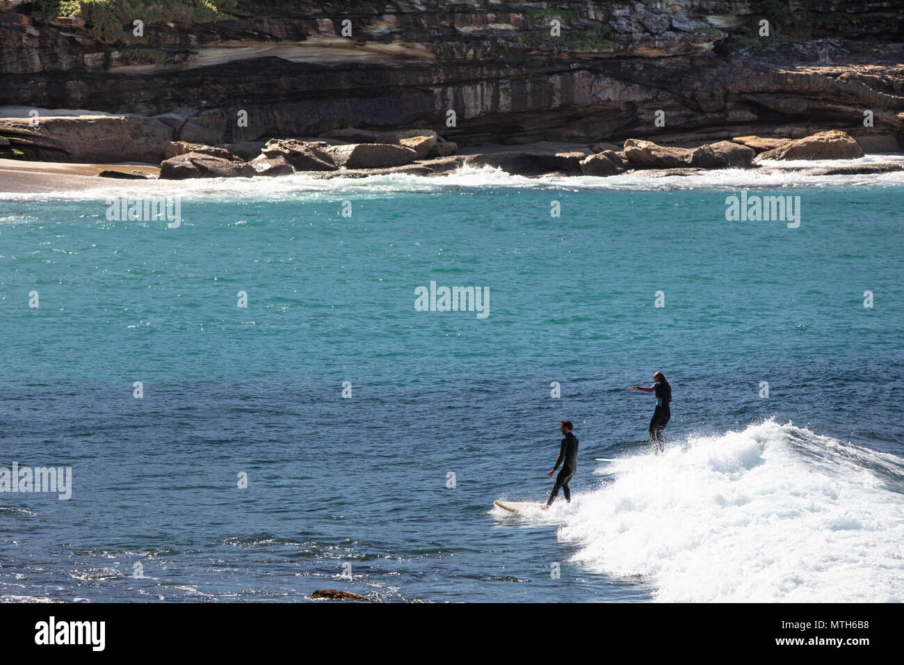 Surfer, die am Bronte Beach in Sydney, New South Wales, Australien, die Wellen fangen Stockfoto