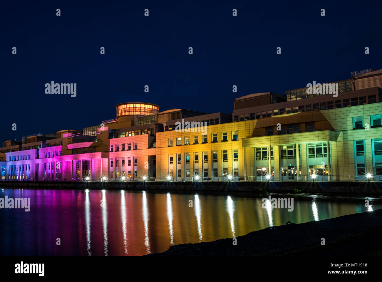 Victoria Quay schottische Regierung Gebäude, in Regenbogenfarben leuchten in der Nacht für den Internationalen Tag gegen Homophobie, Leith, Edinburgh, Schottland, Großbritannien Stockfoto