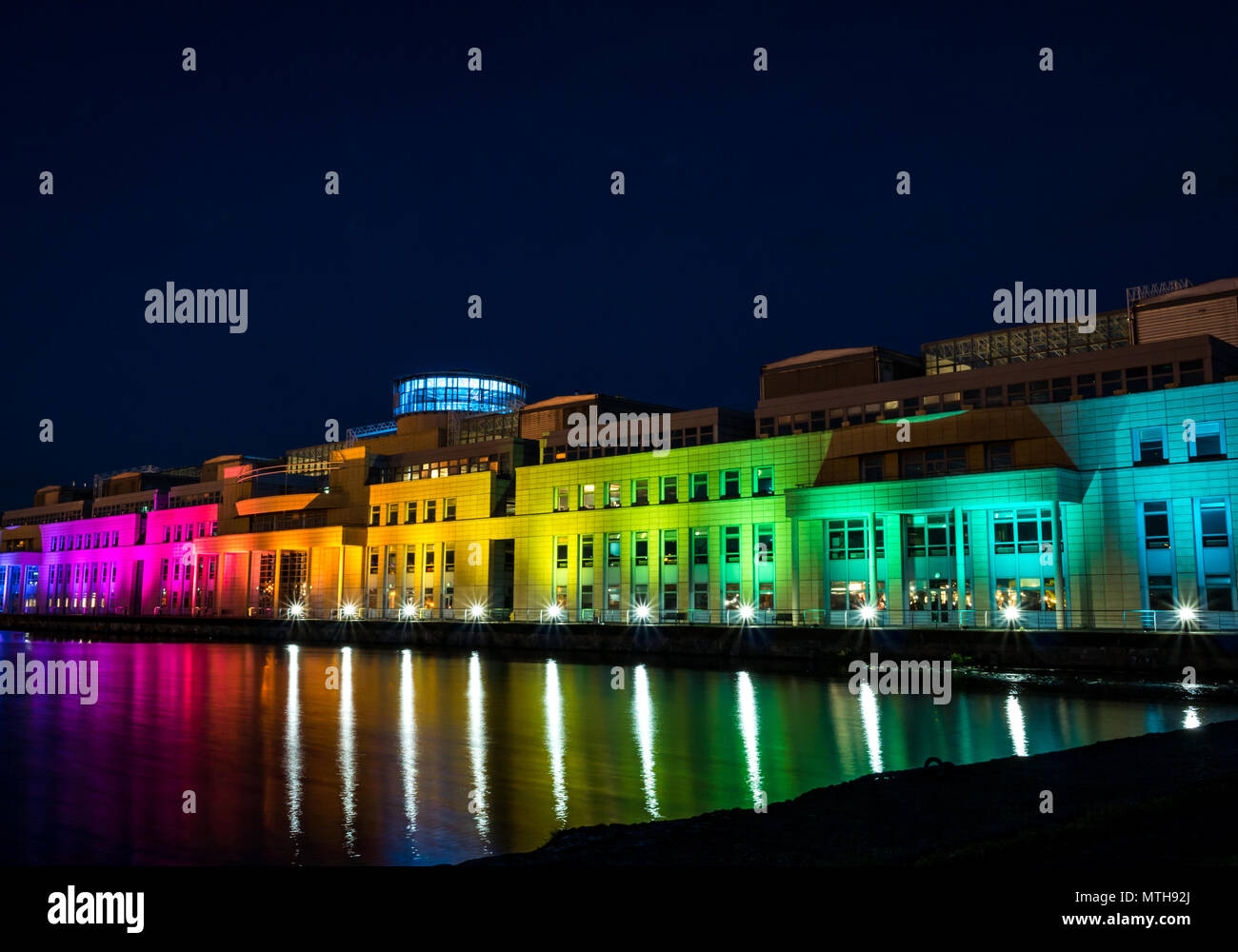 Victoria Quay schottische Regierung Gebäude, in Regenbogenfarben leuchten in der Nacht für den Internationalen Tag gegen Homophobie, Leith, Edinburgh, Schottland, Großbritannien Stockfoto