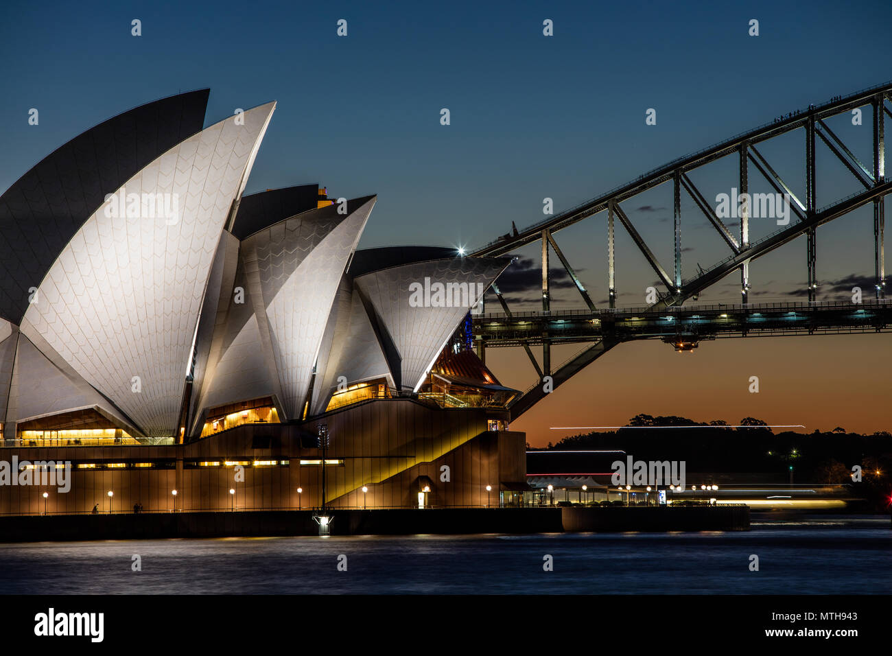 Sydney Opera House und die Harbour Bridge bei Nacht als Harbour Fähre vorbei. Kletterer auf die Sydney Harbour Bridge sind deutlich sichtbar. Stockfoto