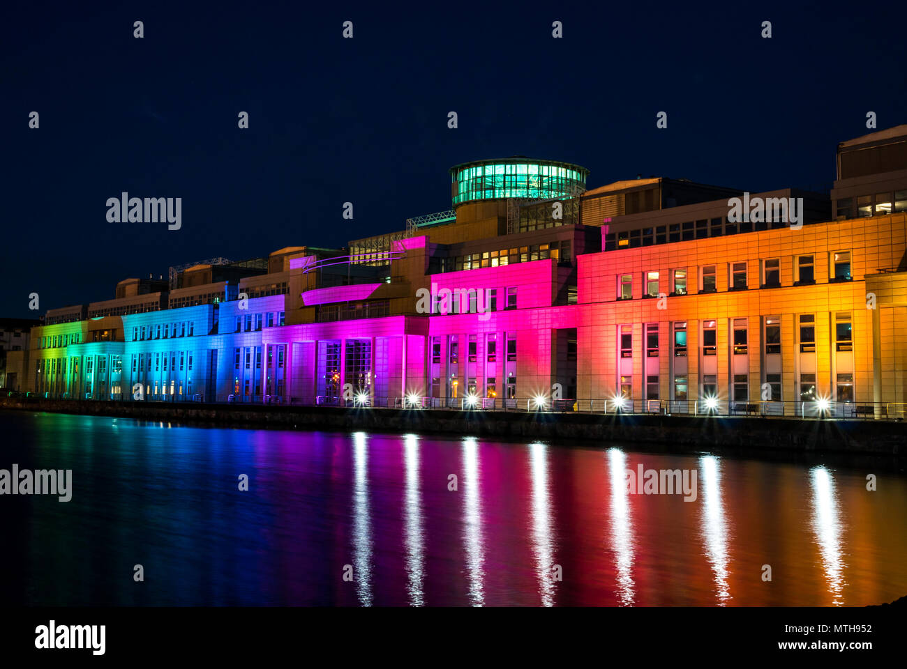 Victoria Quay schottische Regierung Gebäude, in Regenbogenfarben leuchten in der Nacht für den Internationalen Tag gegen Homophobie, Leith, Edinburgh, Schottland, Großbritannien Stockfoto
