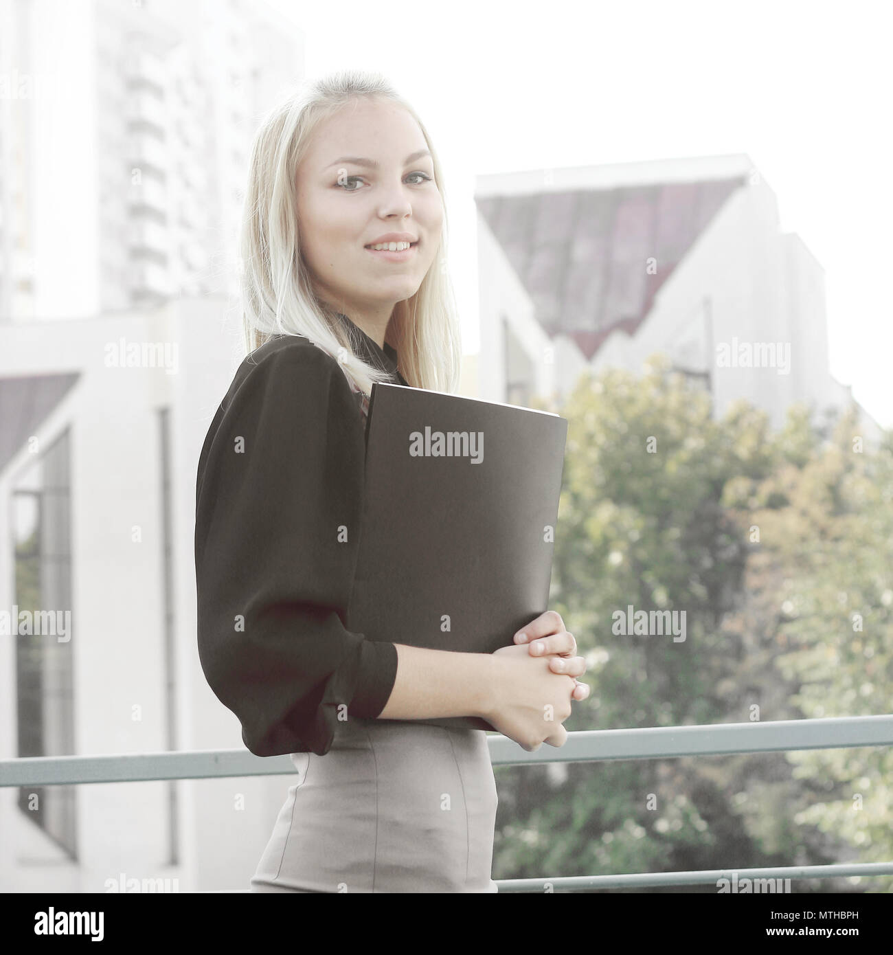 Young Business Frau mit Zwischenablage steht auf dem Balkon des Amtes Stockfoto