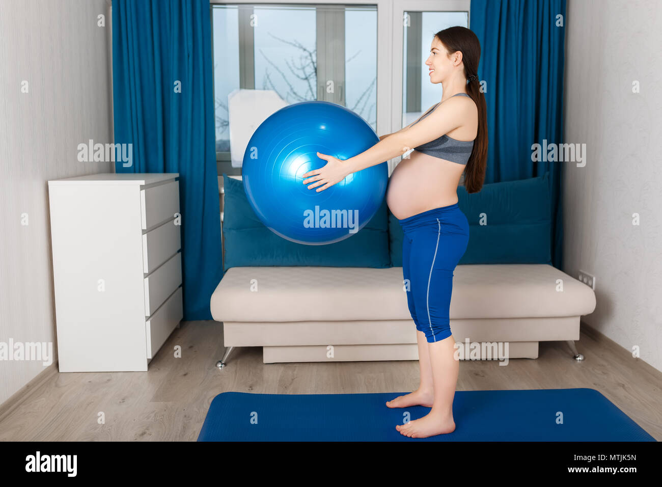 Gerne schwangere Frau Übungen mit Fit Ball zu Hause Stockfoto
