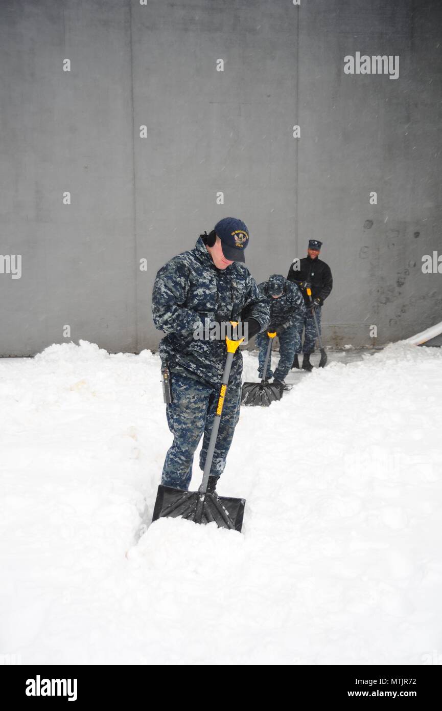 Der Luftfahrt Bootsmann Mate (Start und Wiederherstellung) Airman Zachery Pavey schaufeln Schnee an Bord der Flugzeugträger USS George Washington (CVN 73) im Winter Storm Helena. Das Schiff ist in Norfolk homeported Vorbereitung nach Newport News, Virginia für die Betankung komplex (RCOH) Wartung zu bewegen. (U.S. Marine Foto von Chief Mass Communication Specialist Maria Popejoy/freigegeben) Stockfoto