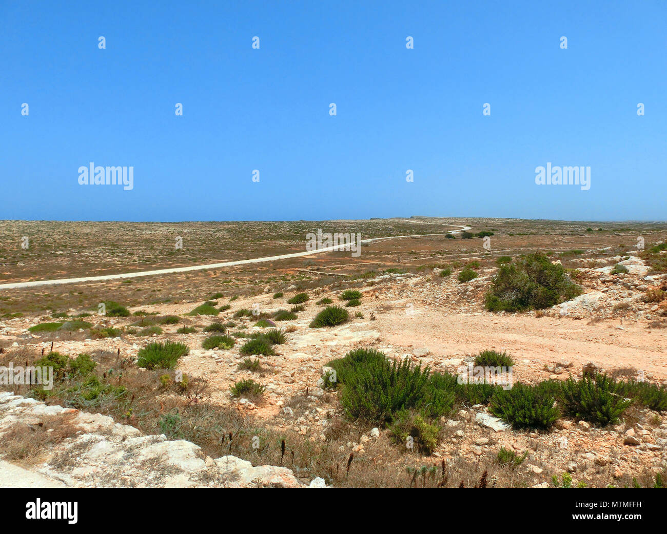 Panorama von einem trockenen und unfruchtbaren Insel mit wenig Vegetation und eine weiße Straße, die zum Meer Stockfoto