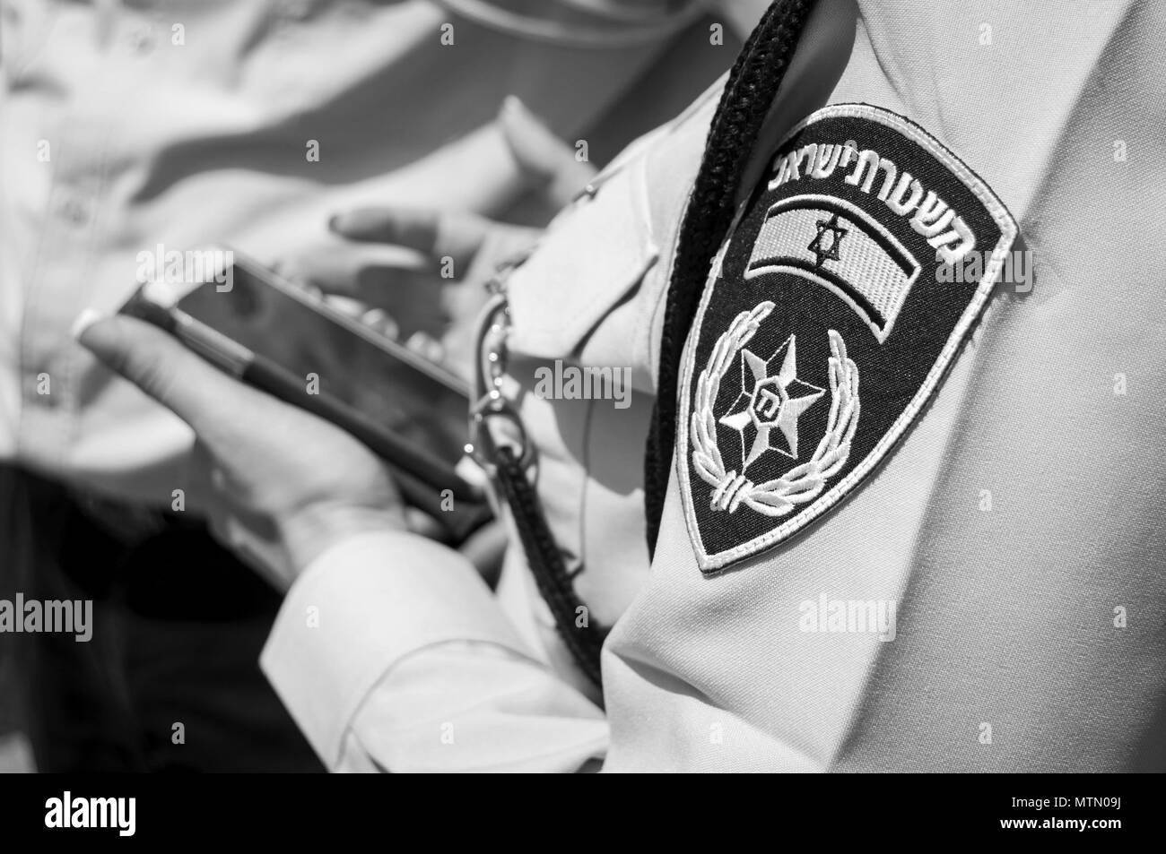 TEL AVIV, Israel. April 9, 2014. Israelische Polizistin mit einem Emblem auf ihrer Uniform holding Handy in den Händen. Israel Polizei Stockfoto