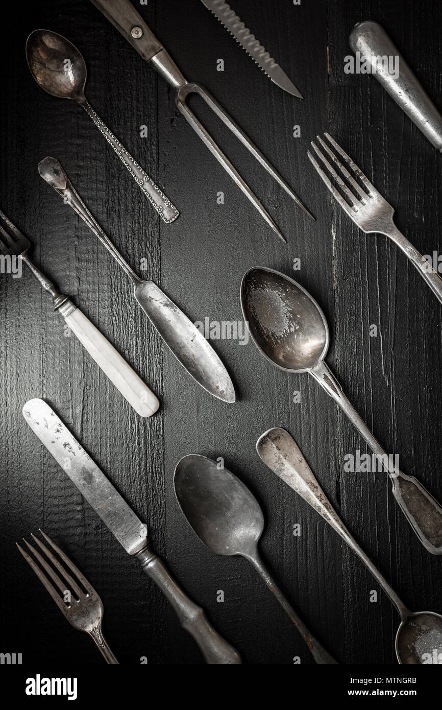 Alte rustikale Besteck auf dunklem Hintergrund. Küche und Essen Konzept. Stockfoto