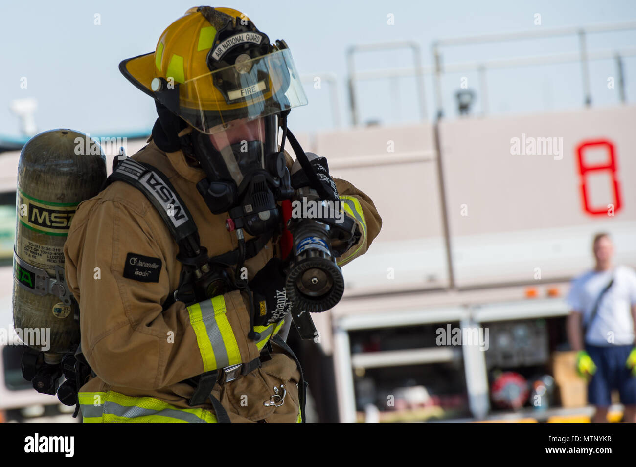 Ein 380 Expeditionary Bauingenieur Squadron Feuerwehrmann schleppt ein Schlauch während eines Routine Feuerwehrmann vertrauen Kurs an einem unbekannten Ort in Südwestasien, Jan. 16, 2017. Teilnehmer neun Etappen während der Kurs inklusive eine Leiter erklimmen, Schlauch ziehen, Schlitten ziehen, Schlauch werfen, Ausrüstung, gewaltsamen Eindringen, hotel Pack, Ausstattung heben und retten. (U.S. Air Force Foto/Senior Airman Tyler Woodward) Stockfoto