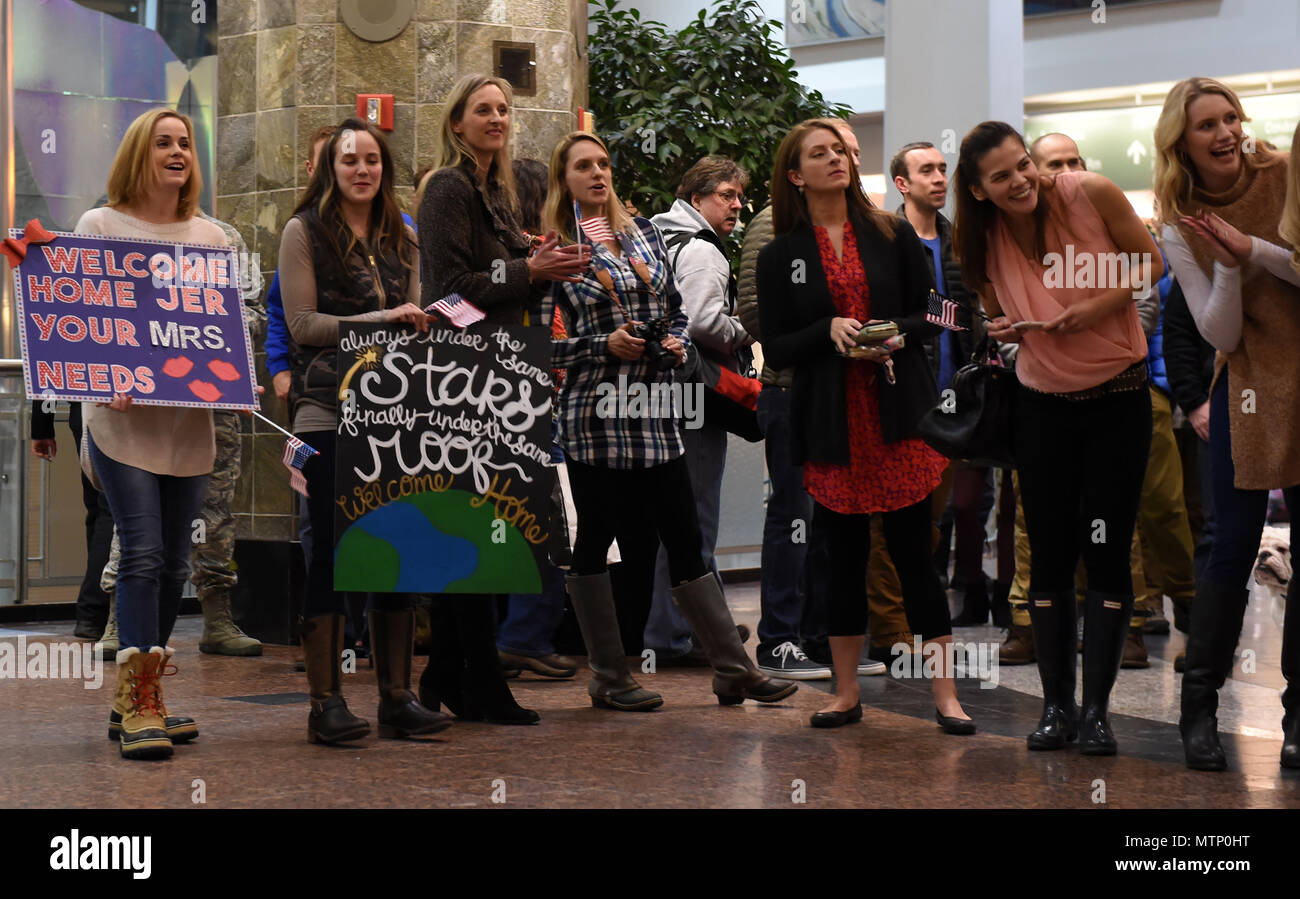 Freunde und Familie warten auf die Rückkehr ihrer Lieben zu Ted Stevens International Airport, Jan. 13, 2016. Eine Gruppe von Mitgliedern der 302d Fighter Squadron und der 525th Fighter Squadron von einem Einsatz zurück nach Südwesten Asien. (U.S. Air Force Foto von Airman 1st Class Javier Alvarez) Stockfoto