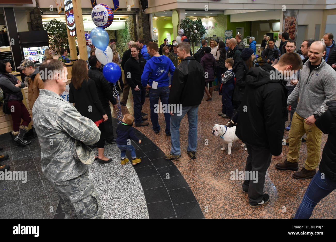 Freunde und Familie sind mit ihren Lieben als JBER Flieger zurück von einem Einsatz bei Ted Stevens International Airport, Jan. 13, 2016 wiedervereinigt. Flieger der 302d Fighter Squadron und der 525th Fighter Squadron zurück von einem Einsatz in Südwestasien. (U.S. Air Force Foto von Airman 1st Class Javier Alvarez) Stockfoto