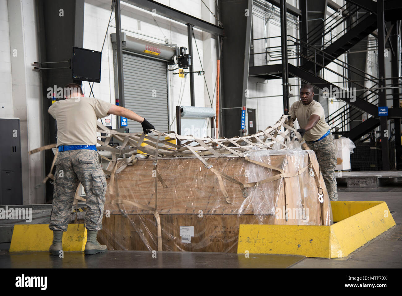 Cargo Prozessoren älterer Flieger Jeffrey Korpics, Antenne Anschluss 436th Squadron, und Senior Airman Terrence Roberts, 46 APS, sicher eine Palette Jan. 12, 2017, bei der die Antenne Anschluss auf Dover Air Force Base, Del je Palette - Gebäude Station senkt für verbesserte Ergonomie und Sicherheit. (U.S. Air Force Foto von älteren Flieger Aaron J. Jenne) Stockfoto