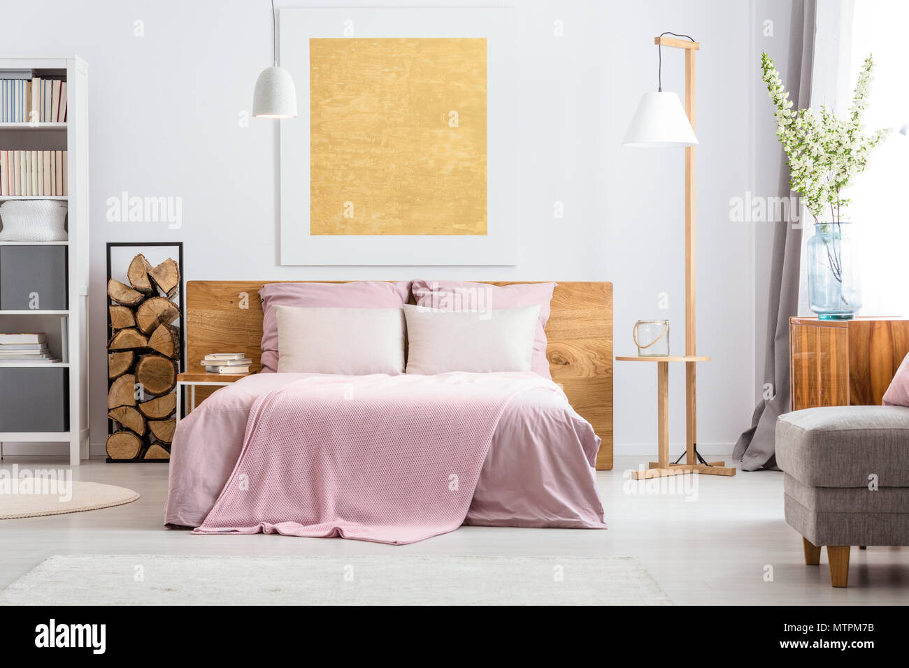 Natürliche Ausstattung der gemütlichen weißen und rosa Schlafzimmer mit Holz- Ergänzungen Stockfoto