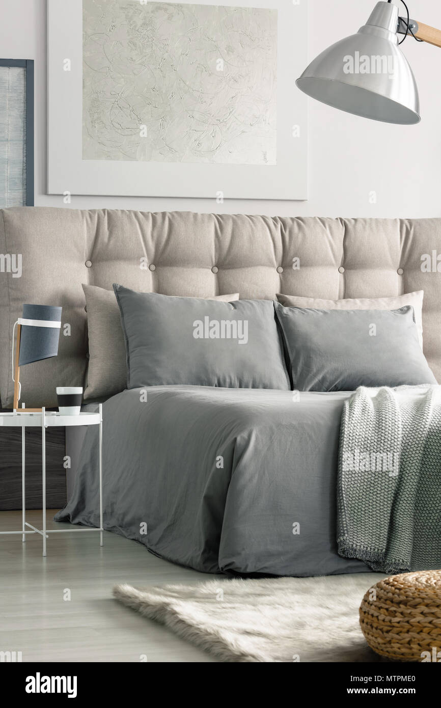 Geräumiges, modernes Schlafzimmer mit großem Bett in grauen Farben Stockfoto