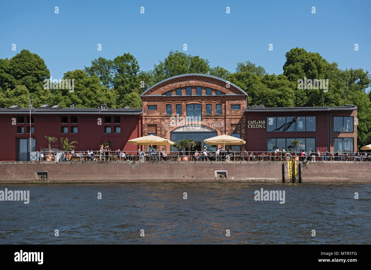 Cafe mit Gästen am Ufer der Trave in Lübeck, Deutschland Stockfoto