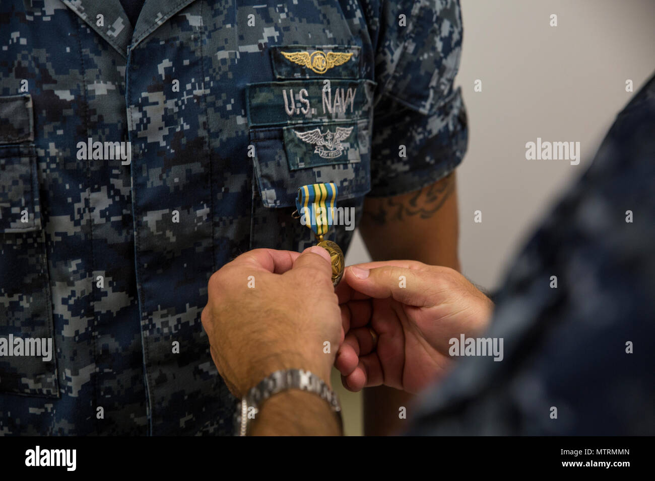 MARINE CORPS BASE HAWAII-Rear Admiral John Weigold, Reserve stellvertretender Kommandeur mit US-Pazifikflotte, präsentiert eine militärische hervorragende Volunteer Service Medal, Petty Officer 1st Class Brandon Thompson, ein Crew-Chief Fleet Logistics Support Squadron 51 und gebürtig aus Bonners Ferry, Idaho, während einer feierlichen Preisverleihung im Hangar 5 an Bord der Marine Corps Air Station Kaneohe Bay statt , Marine Corps Base Hawaii, am 18. Januar 2017.  Weigold besucht VR-51 im Rahmen einer Inselrundfahrt der naval Reserve-Einheiten in denen er mit Seglern interagiert, die Männer und Frauen unter seinem Kommando zu treffen. (US-Marine Stockfoto