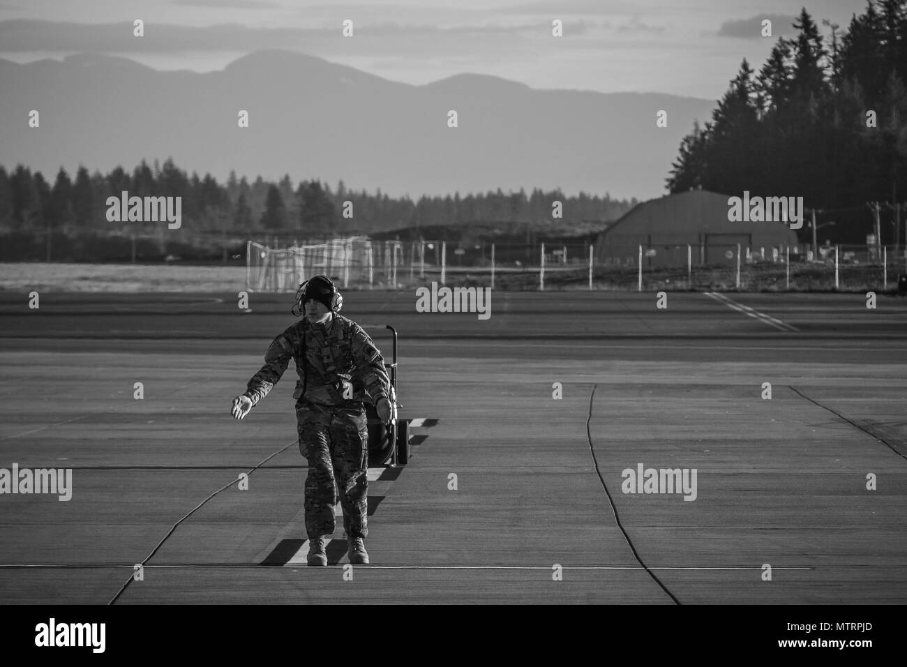 Ein AH-64E Apache Helikopter Crewchef der 16. Combat Aviation Brigade steuert das Flugzeug vor einem Trainingsflug auf der Joint Base Lewis-McChord. Piloten absolvieren Simulations- und Flugschulungen, um die Bereitschaft und Befähigung zum Einsatz von Hubschraubern zu erhalten. Die Brigade ist Teil der 7. Infanterie-Division unter dem I-Korps. Das Training findet im Pazifischen Nordwesten in der Nähe des Mount Rainier statt, wobei der Schwerpunkt auf taktischen Manövern, der Koordination der Besatzung und DER Einsatzbereitschaft mit Apache und UH-60M Black Hawk Hubschraubern liegt. Stockfoto