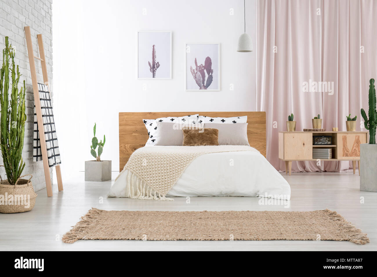 Beige Teppich vor King-size-Bett in der Nähe von Leiter und Schrank in  geräumigen Schlafzimmer mit Cactus Motiv Stockfotografie - Alamy