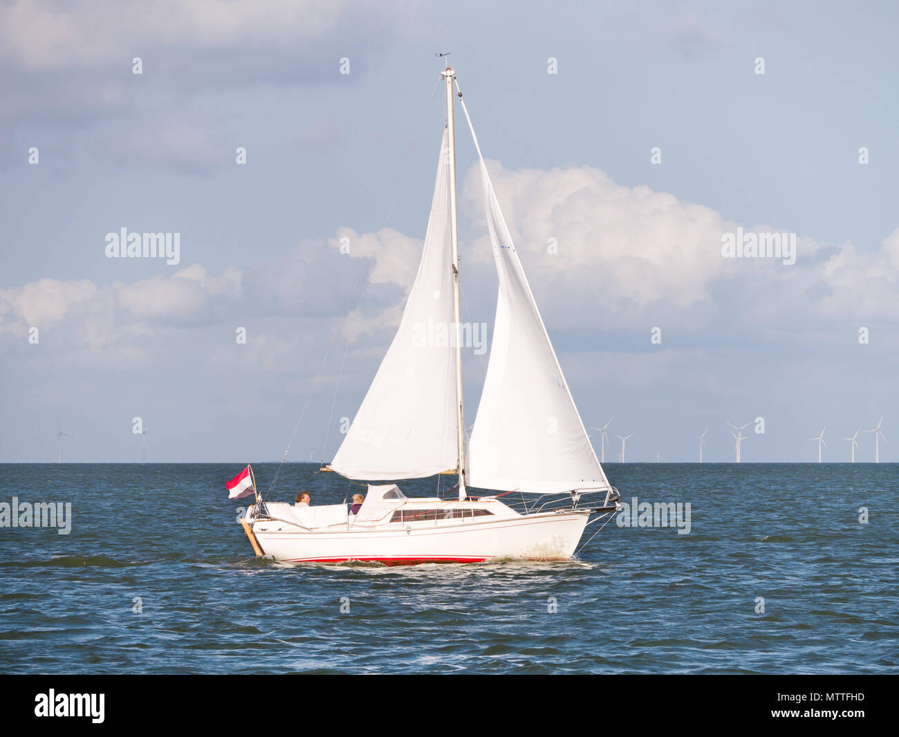 Menschen auf Segelboot Segeln auf dem IJsselmeer und Windenergieanlagen des Windparks Urk, Niederlande Stockfoto