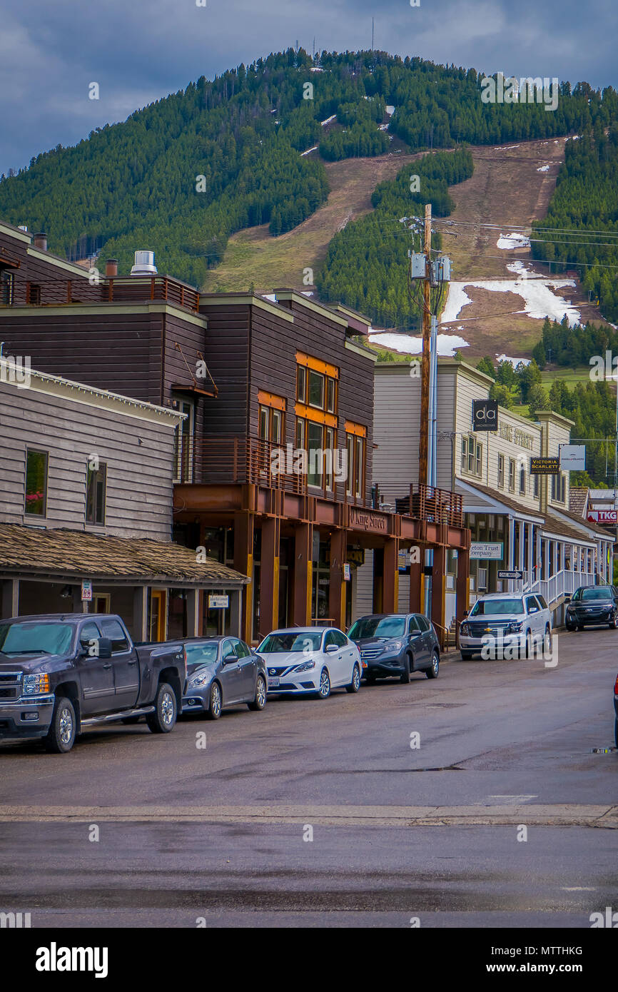 Jackson Hole, USA - 23. Mai 2018: Im freien Blick auf die Skipisten in Jackson Hole Mountain hinter der herrlichen Häuser Gebäude mit Autos auf einer Seite der Straße geparkt Stockfoto