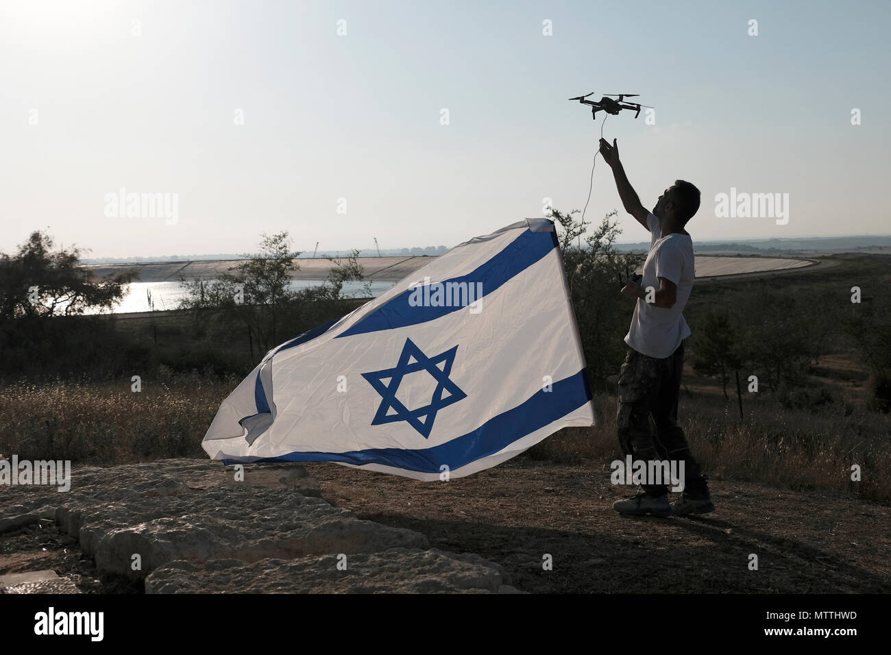 Ein israelischer Zivilist, der am 29. Mai eine Quadrocopter-Drohne in der Nähe des NIR am Kibbuz nahe der Grenze zum Gazastreifen betreibt, mit der israelischen Flagge. Das israelische Militär hat am Dienstag nach einem Raketenfeuer aus dem Gazastreifen eine Reihe von Luftangriffen auf palästinensische Stellungen in Gaza gestartet. Stockfoto