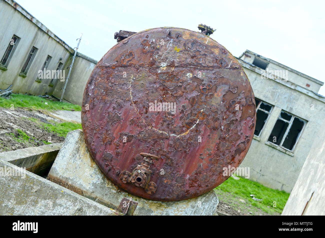 Smiley gezeichnet oder auf einem alten rostigen Öltank graffitied Stockfoto