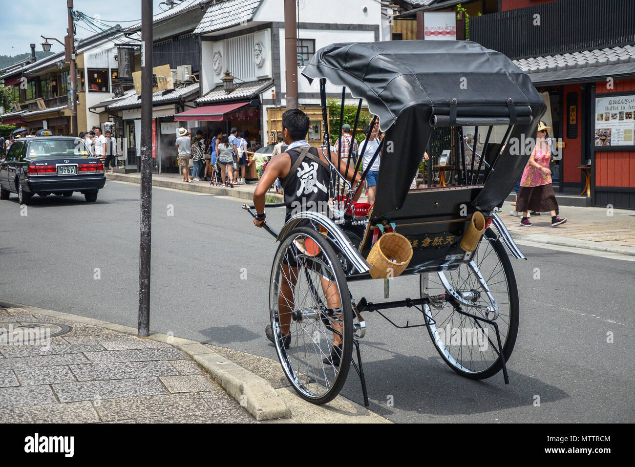 Kyoto, Japan - 24. Juli 2016. Straße in Kyoto an einem Sommertag im Juli, ein Mann, eine Rikscha ziehen. Stockfoto