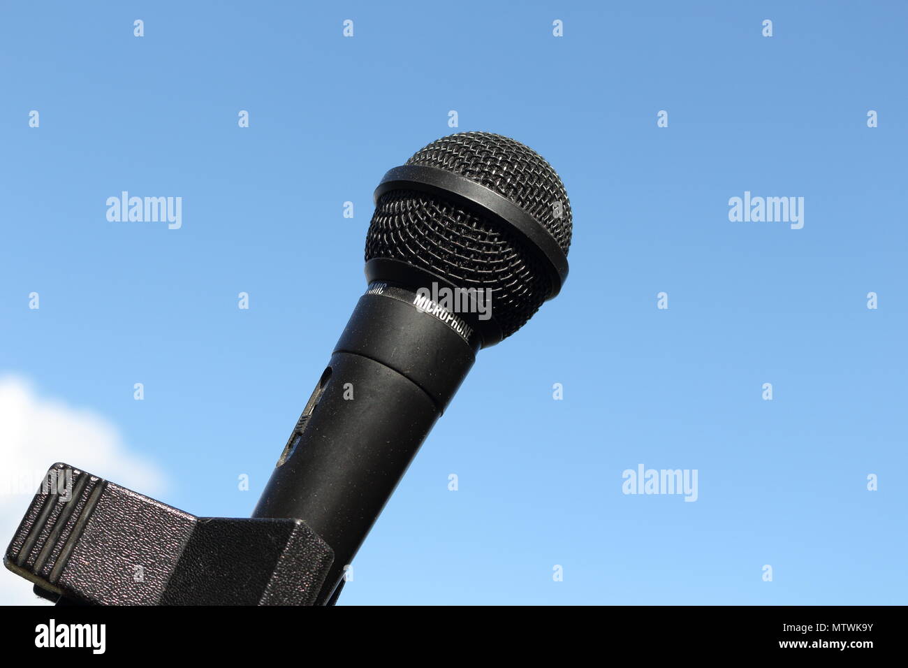 In der Nähe von schwarzen, glänzenden Mikrofon mit klaren, blauen Himmel Hintergrund an einem sonnigen Sommer Stockfoto