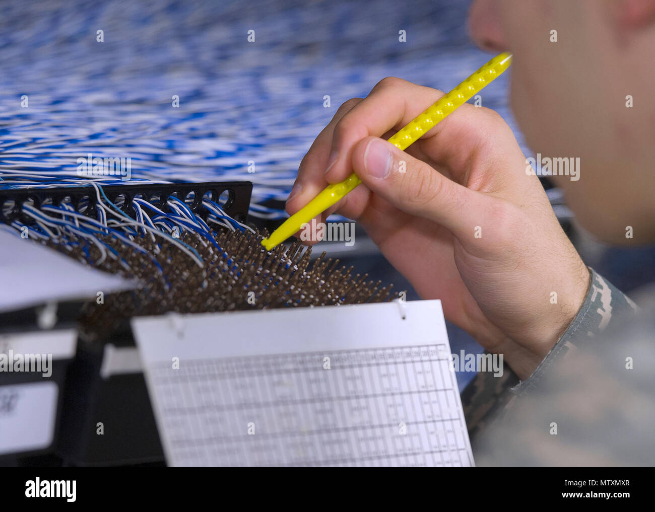 Eine einzelne Telefonleitung wird manuell nachverfolgt, Jan. 27, 2017, durch den Hauptverteiler der 88th Communications Squadron Telefon Reparatur Shop at Wright-Patterson Air Force Base, Ohio. Als Grundlage der Übergänge zu Voice over Internet Protocol, die Notwendigkeit, zu verwalten und zu verfolgen Zehntausende zeilen Weg. (U.S. Air Force Foto von R.J. Oriez/Freigegeben) Stockfoto