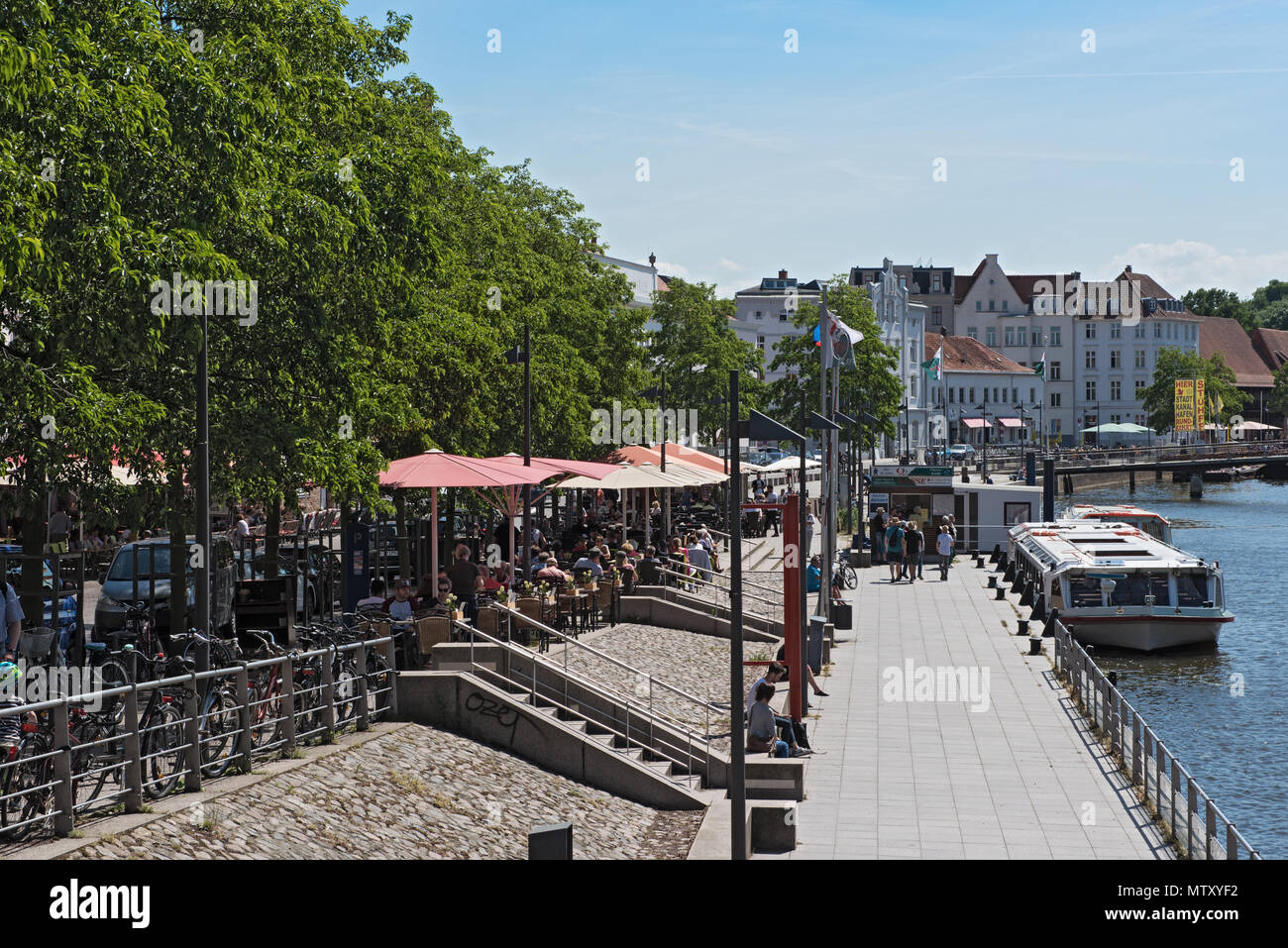 Cafés mit Touristen am Ufer der Trave in der Altstadt von Lübeck, Deutschland Stockfoto