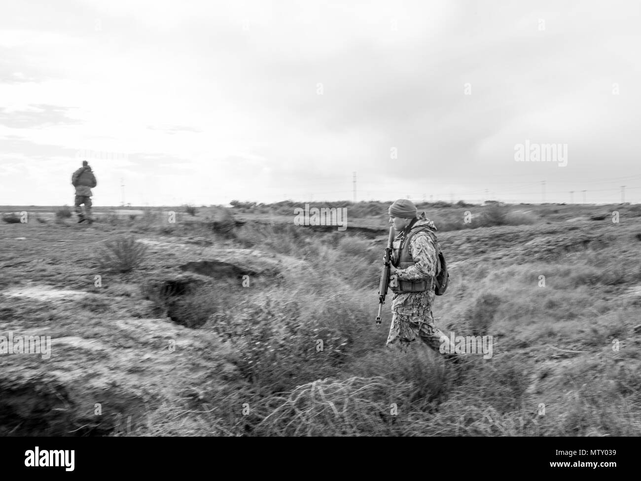 CAMP Pendleton, Calif (Jan. 23, 2017) - steelworker 3. Klasse Josua Kopit, Amphibischen Bau Bataillon 1 angeschlossen ist, fährt eine Wasserrinne Während auf Patrouille im Bereich Training (Ftx) 2017. FTX 2017 ist ein Szenario-basierte Übung entwickelt, Zug das Bataillon in Seabee bekämpfen Kriegsführung und zu testen. (U.S. Marine Foto von Mass Communication Specialist 2. Klasse Eric Chan/Freigegeben) Stockfoto