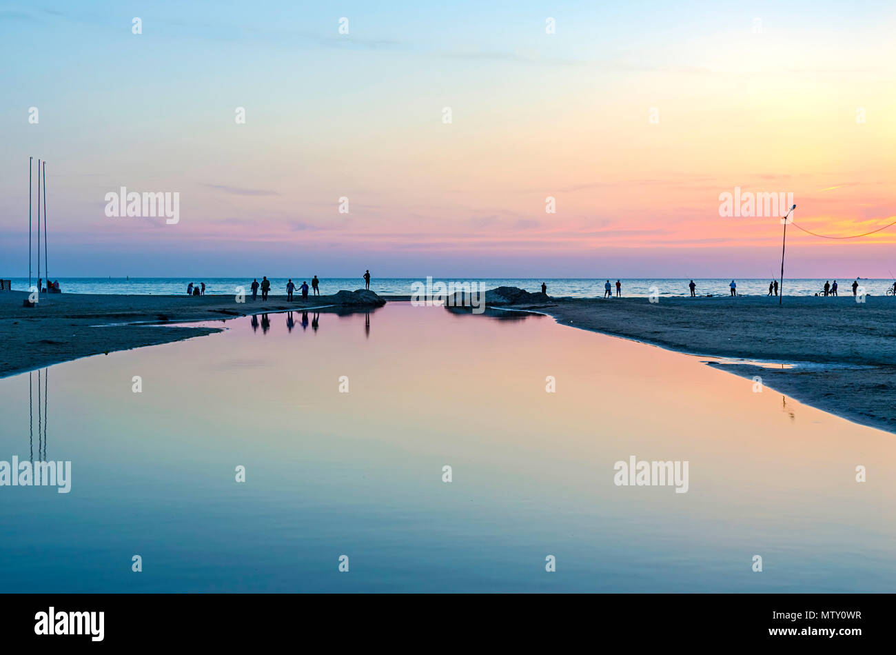 Touristen und Fischer sind am Schwarzen Meer und genießen Sie den schönen Sonnenuntergang. Stockfoto