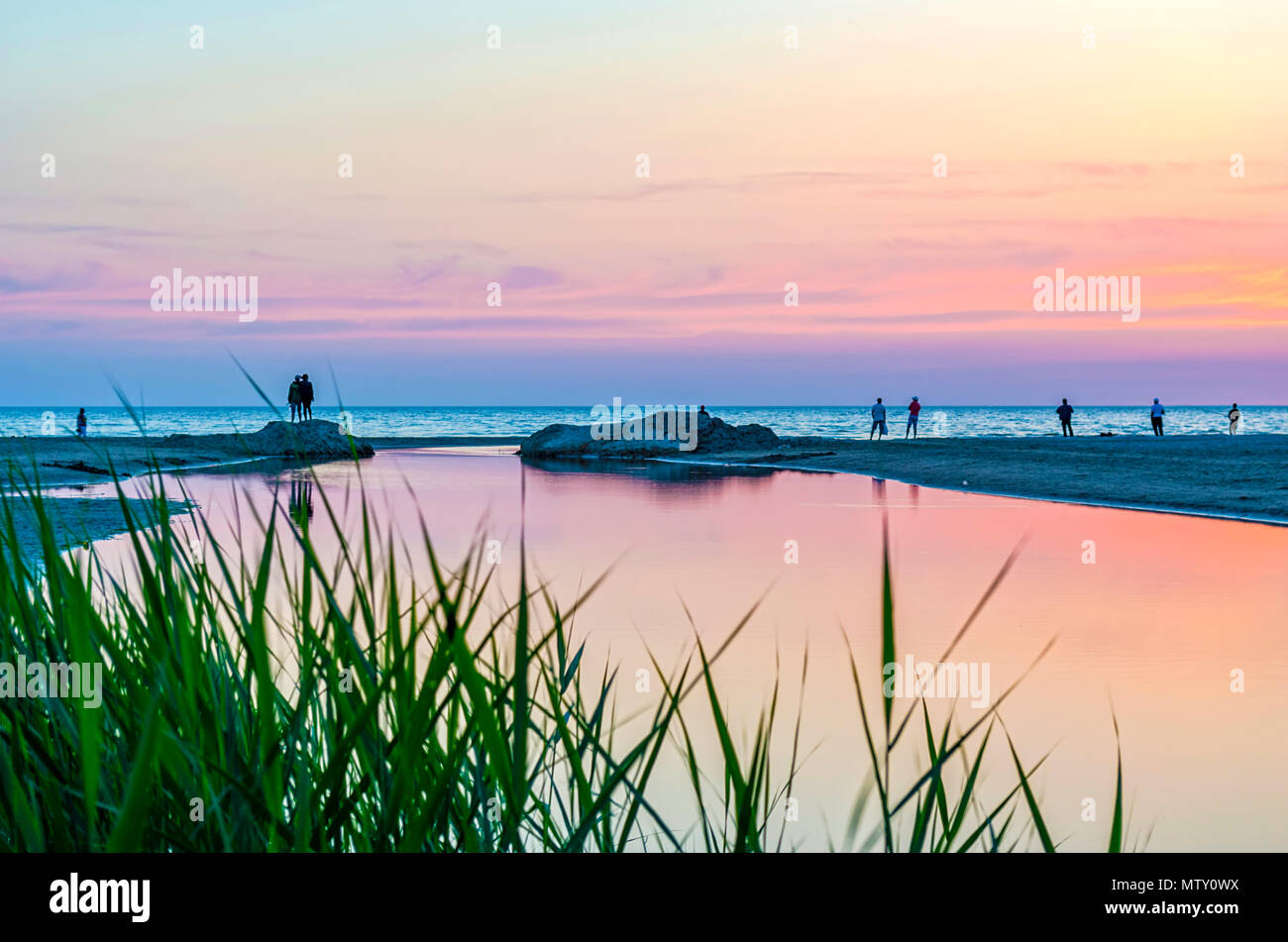 Touristen und Fischer sind am Schwarzen Meer und genießen Sie den schönen Sonnenuntergang. Ein Paar in Liebe nimmt eine selfie gegen den Sonnenuntergang. Stockfoto