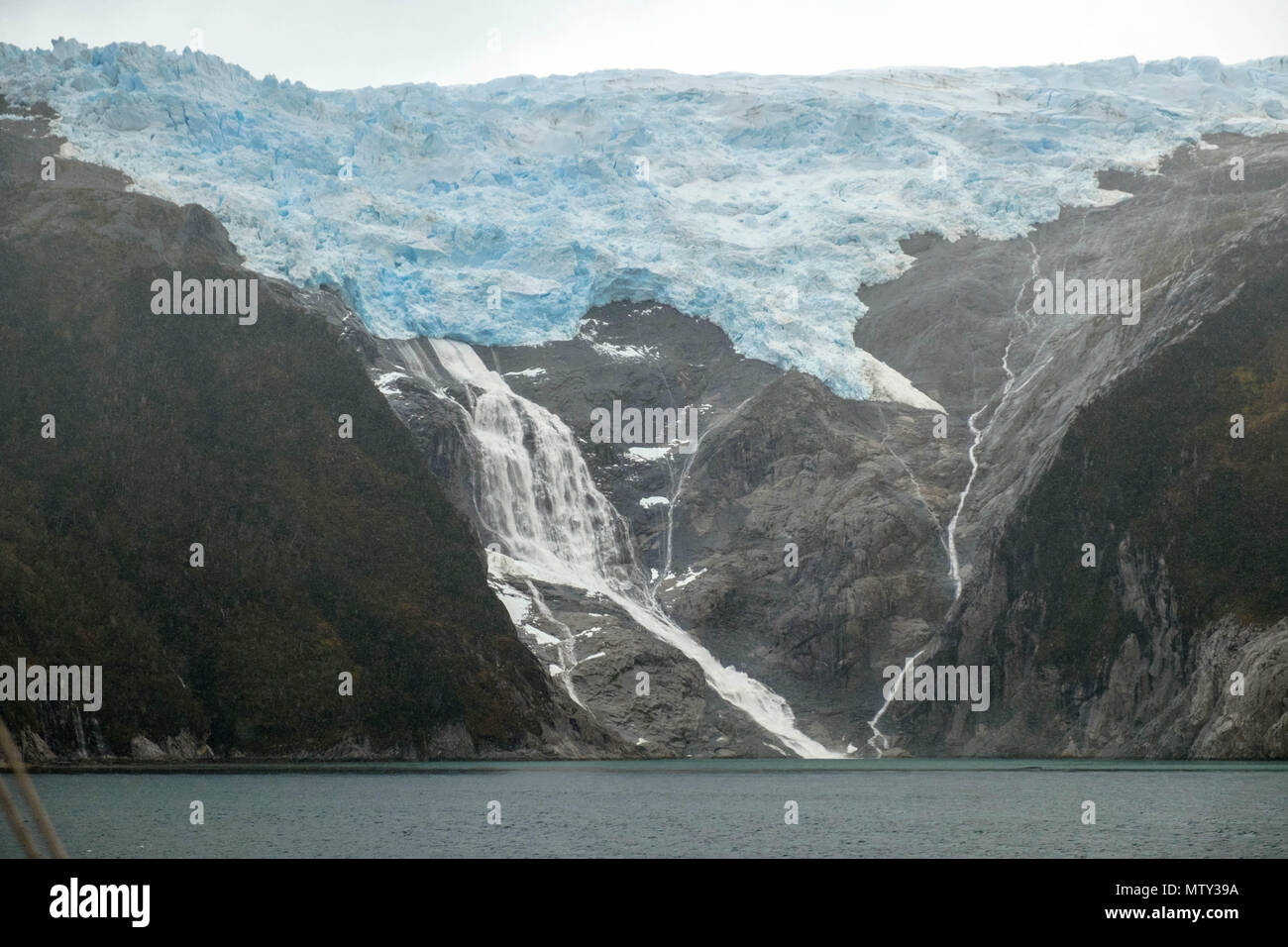 Ein Gletscher wirft die Eisschmelze in den Beagle Kanal, wie aus einer Fähre gesehen-Kreuzfahrt von Punta Arenas nach Puerto Williams, beide in Chile. Stockfoto