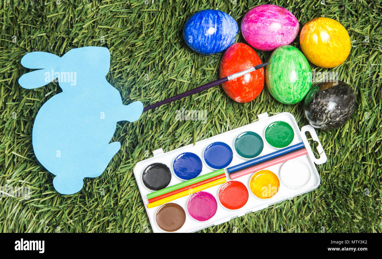 Karte Osterhase mit Pinsel auf der Hand, malen Eier in sechs Farben Stockfoto