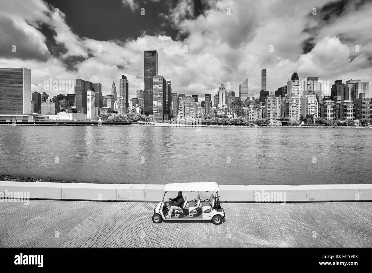 New York City, USA - 26. Mai 2017: Pkw Golf Cart auf der Franklin D. Roosevelt vier Freiheiten Park Promenade, New York City Skyline im Hintergrund. Stockfoto