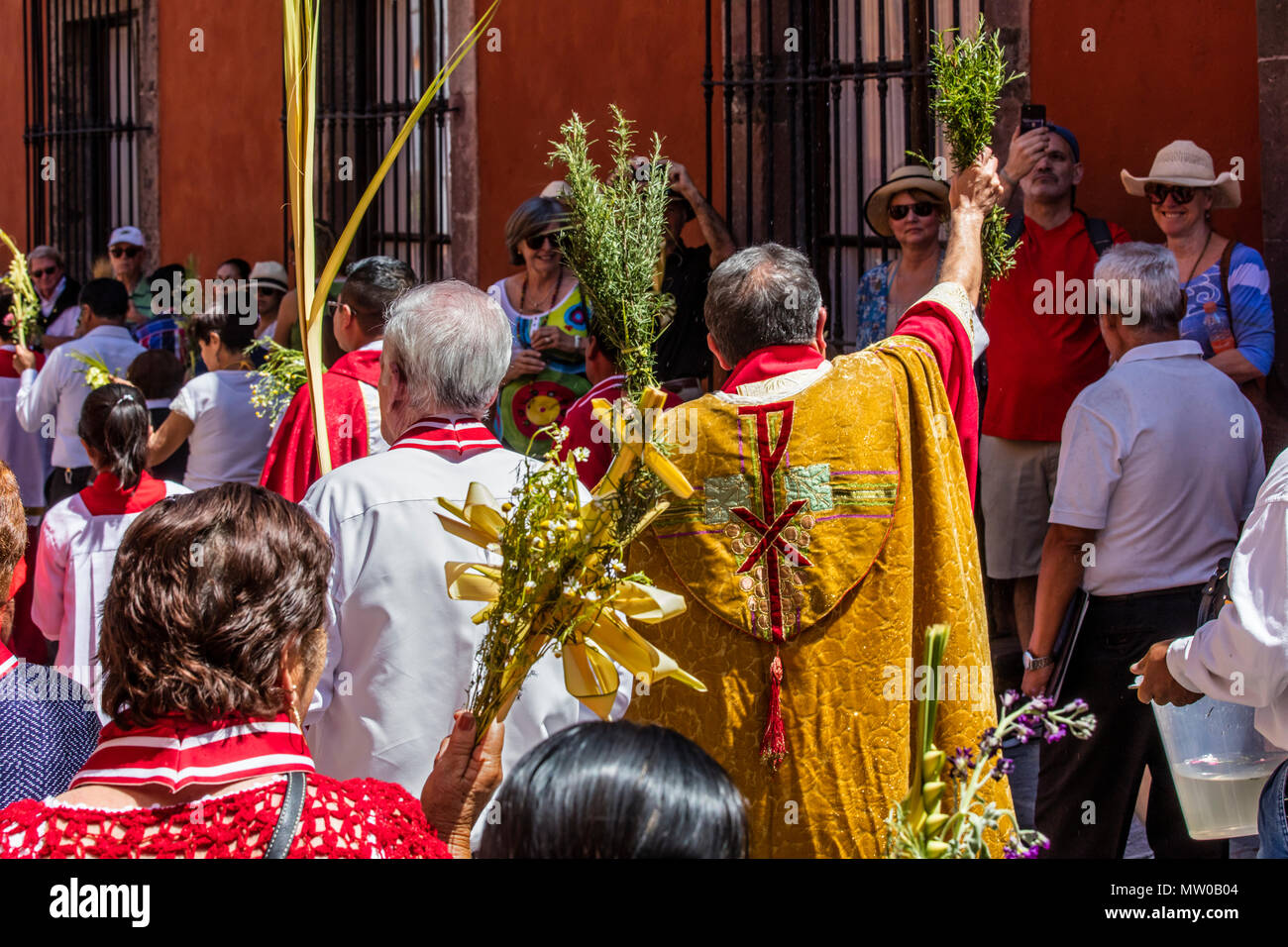 Katholische Priester sprengen Weihwasser auf die Gläubigen während der palmsonntag Prozession vom Parque Juarez zum Jardin - San Miguel de Allende, Mexiko Stockfoto