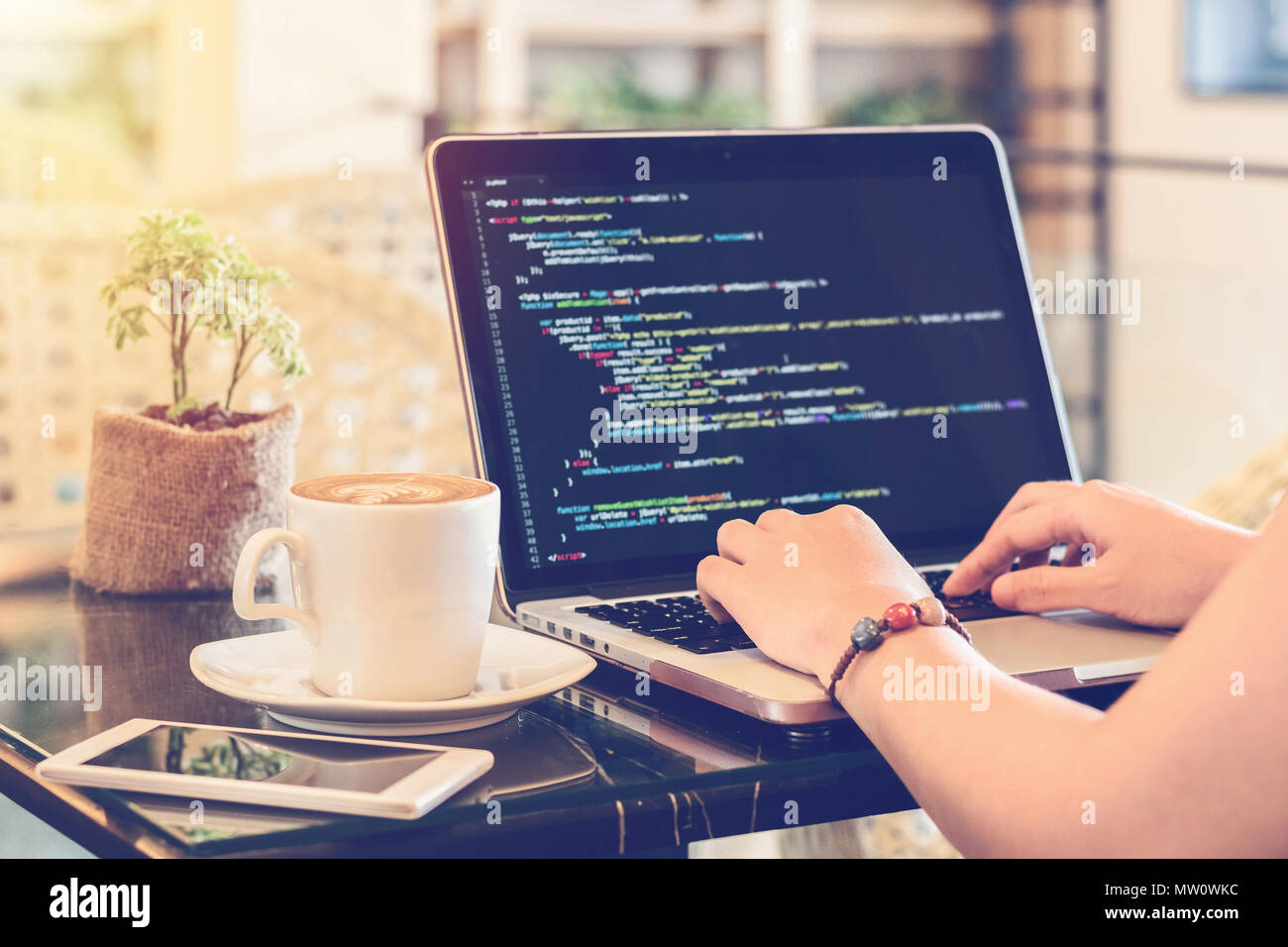 Ein Programmierer mit der Eingabe von Quellcode in einem Coffee Shop. Studium, Arbeit, Technik, freie Mitarbeit, Webdesign und Web Development Konzept. Stockfoto