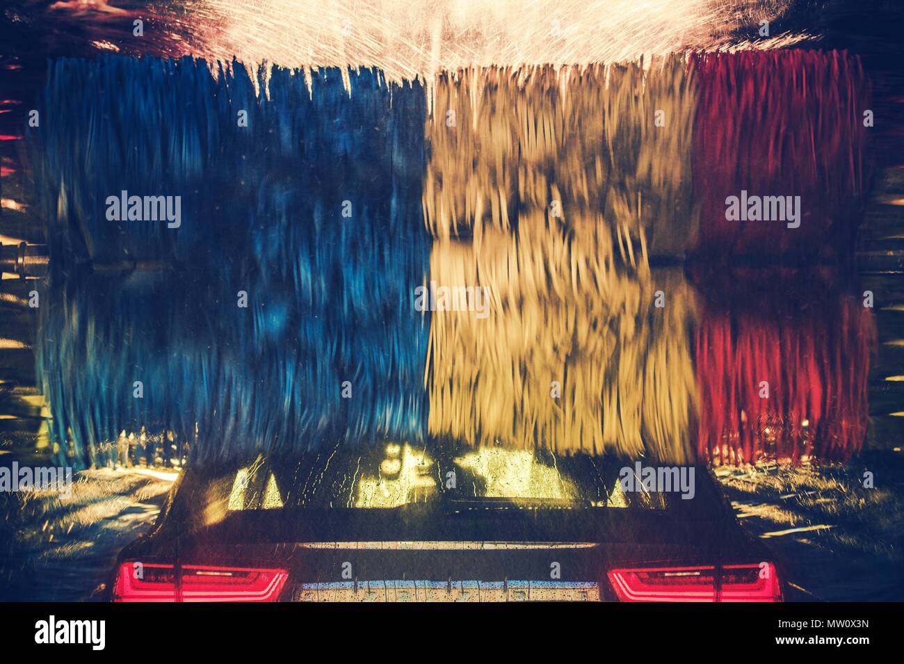Bunte Auto waschen in Aktion. Modernes Fahrzeug innerhalb der rotierenden Waschbürsten. Stockfoto