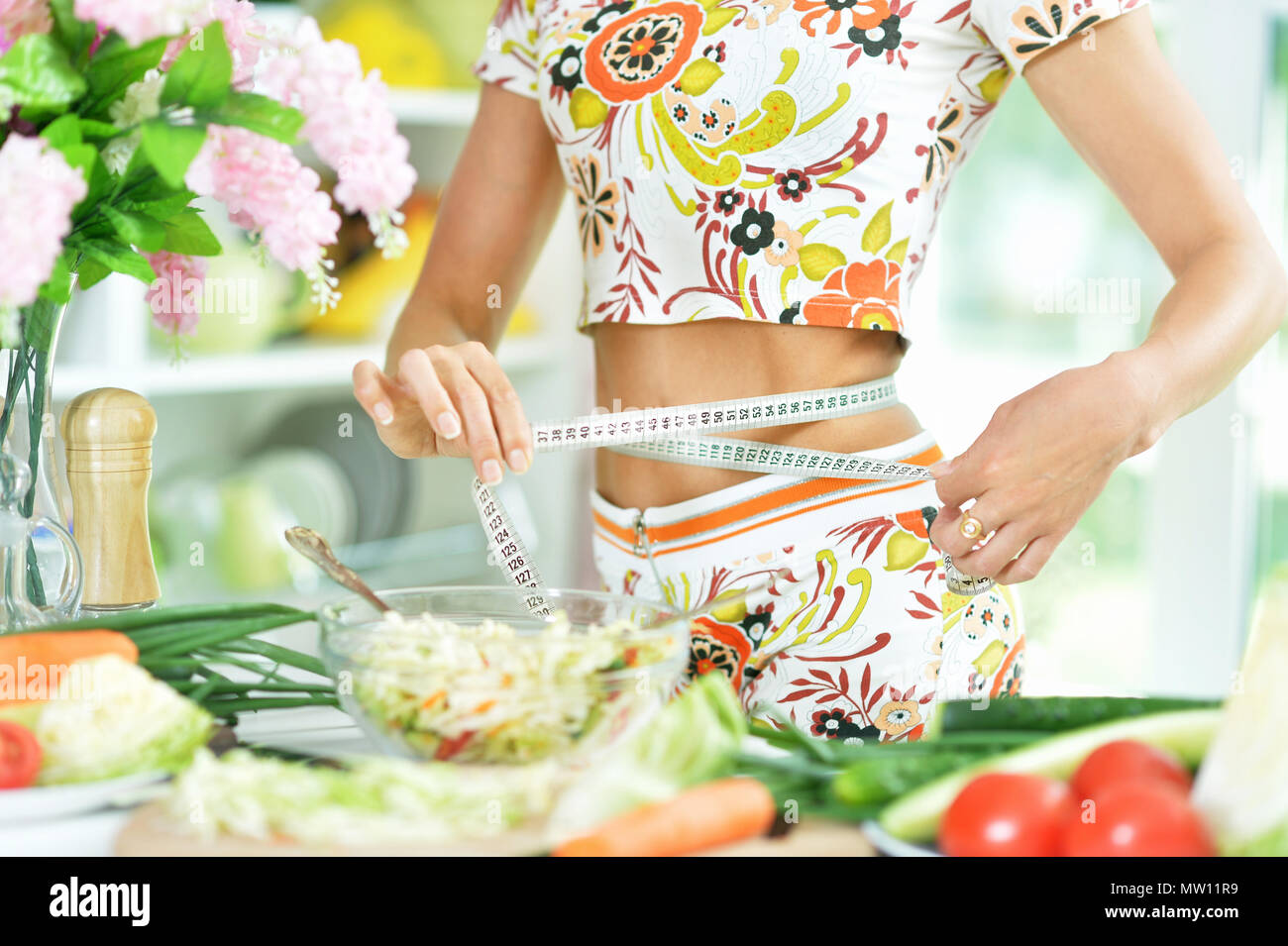 junge Frau bereitet Salat Stockfoto